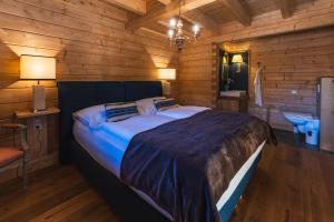 a bedroom with a large bed in a log cabin at Schlosswirt Chalets & Apartments in Großkirchheim