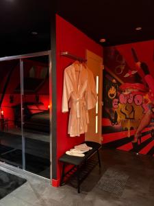 eine Ankleidekabine mit einem Mantel an der Wand in der Unterkunft Spa2Luxe - L Interdite in Saint-Quentin
