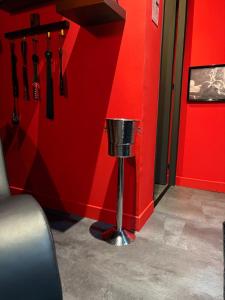 eine rote Wand mit einem Mülleimer in einem Zimmer in der Unterkunft Spa2Luxe - L Interdite in Saint-Quentin