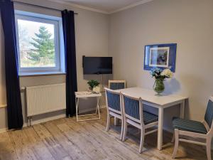 a dining room with a table and chairs and a television at 11 Haselnuss - Hof Wiesengrund in Parchtitz