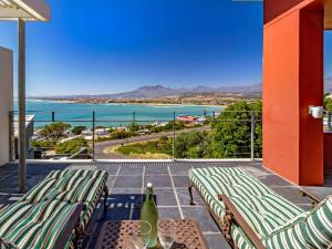 a balcony with chairs and a view of the ocean at 5 Suikerbossie in Gordonʼs Bay