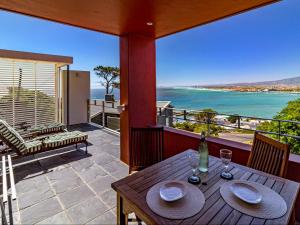 a table on a balcony with a view of the ocean at 5 Suikerbossie in Gordonʼs Bay