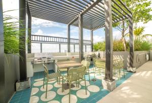 a patio with tables and chairs and a pergola at Crosby Miami World Center in Miami