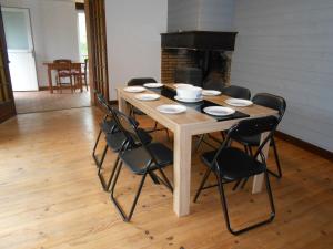 a wooden table with chairs and a fireplace in a room at location Mirande 3 chamb 8 couchages 9 rue de soupon in Laruns