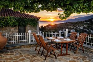 a table and chairs on a patio with a sunset at Vista Mare in Afissos