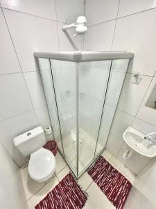 a bathroom with a shower and a toilet and a sink at Quarto 06 - Pousada Canaã in Recife
