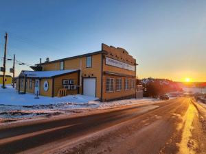 a building on the side of a road with the sunset at Bumblebee Bight Inn in Pilleyʼs Island