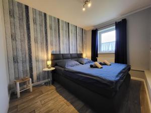 a bedroom with a bed with blue sheets and a window at 10 Walnuss - Hof Wiesengrund in Parchtitz +30 photos