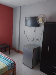a room with a small refrigerator and a fan at Casa Ibañez in Talara