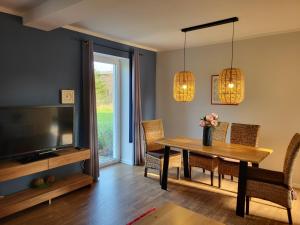 a dining room with a table and a television at 10 Walnuss - Hof Wiesengrund in Parchtitz