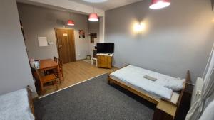 a bedroom with a bed and a desk and a table at KEISA APARTRooms in Nowy Sącz