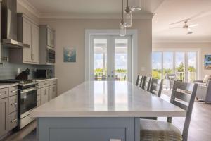 a kitchen with a large white table and chairs at Springtide House -Dock & Home w Pool in Stock Island