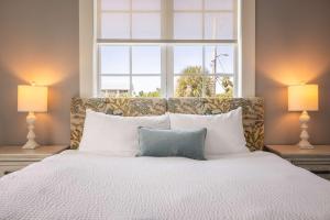 a bedroom with a large bed with two lamps at Springtide House -Dock & Home w Pool in Stock Island +26 photos