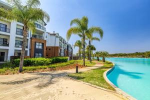a pathway next to a pool with palm trees at The Blyde Luxury Apartments in Pretoria