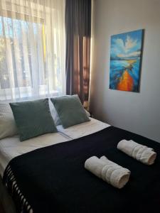 a bedroom with a large bed with two towels on it at Home4You free park in Krakow