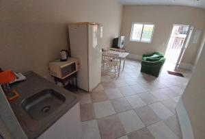 a kitchen with a refrigerator and a table in it at Básico e funcional, com 2 ambientes, sem fogão, com garagem, zona nobre in Pelotas +10 photos