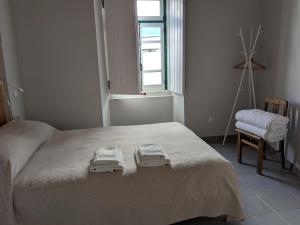 a bedroom with a bed with two towels on it at Estudio 21 in Cercal