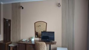 a room with a desk with a television and a mirror at Hotel COLISEUM in Calafat