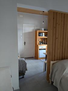 a room with a kitchen with a bed and a table at Estudio 21 in Cercal