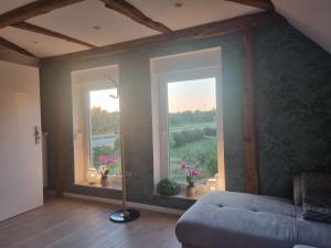 a living room with a couch and two windows at Lewitz-Urlaub in Lübesse