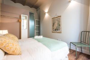 a bedroom with a white bed and a chair at Boutike Apartments in Seville