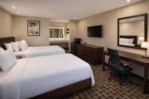 a hotel room with two beds and a desk at Spring Place Inn & Suites in Millington