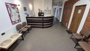 a waiting room with chairs and a counter in a building at KEISA APARTRooms in Nowy Sącz