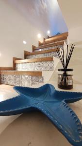 a blue fish shaped bench in front of a staircase at Luxury House in Cefalù