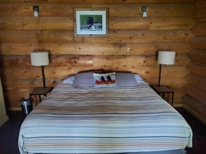 a bedroom with a bed in a log cabin at Sunset Bay Lodge in Abbeyville