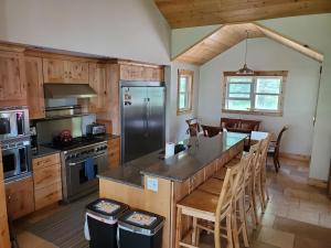 a kitchen with a stainless steel refrigerator and wooden cabinets at Sunset Bay Lodge in Abbeyville
