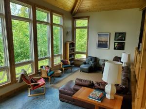 a living room with leather furniture and large windows at Sunset Bay Lodge in Abbeyville