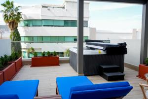 a balcony with blue chairs and a building at Kadun Hotel Boutique in Cabo San Lucas