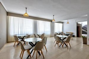 a dining room with tables and chairs and windows at Argassi Beach Hotel - Adults Only in Argassi
