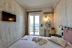 a bedroom with a bed with a view of the ocean at Argassi Beach Hotel - Adults Only in Argassi