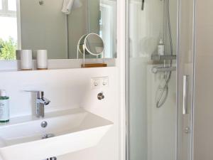 a white bathroom with a sink and a mirror at Backbord Geesthacht in Geesthacht +27 photos
