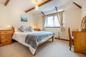 a bedroom with a bed and a dresser and a window at 3 Bed in St. Merryn oc-m29320 in Saint Merryn