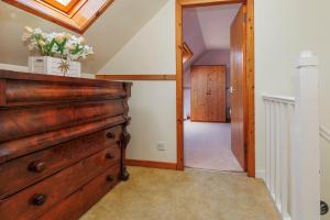 a room with a wooden dresser and a hallway at Cosy Croft in Lower Shader