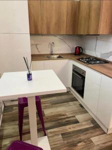 a white kitchen with a table and a sink at Mini white apartment in Scandicci