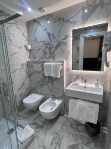 a bathroom with a sink and a toilet and a mirror at Hotel Garda in Rome