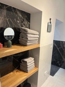 a pile of towels on a shelf in a bathroom at Moderne Apartments in Wicker in Flörsheim am Main
