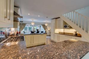 a kitchen with white cabinets and a stair case at 4 Bed in Ovingdean oc-bbvale in Rottingdean