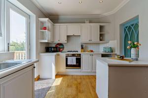 a kitchen with white cabinets and a large window at 3 Bed in Mumbles oc-b27725 in The Mumbles +23 photos