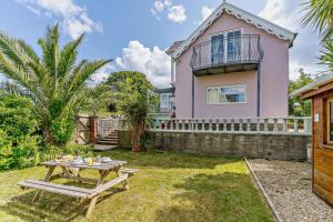 a pink house with a picnic table in the yard at 3 Bed in Mumbles oc-b27725 in The Mumbles