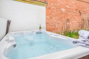 a bath tub with a bottle of wine in it at 4 Bed in Alcester oc-s30997 in Alcester +32 photos