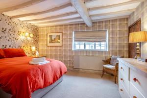 a bedroom with a red bed with a laptop on it at 4 Bed in Alcester oc-s30997 in Alcester