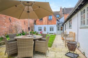 a patio with a table and chairs with an umbrella at 4 Bed in Alcester oc-s30997 in Alcester