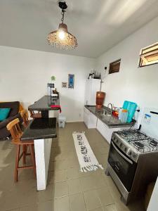 a kitchen with a sink and a stove top oven at CASA in Piranhas +16 photos