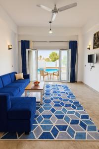 a living room with a blue couch and a blue rug at Villa Desert Rose in Luxor