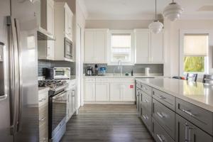 a white kitchen with white cabinets and white appliances at Seagate House -Waterfront w Dock in Key West