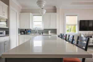 a large white kitchen with a large white table at Seagate House -Waterfront w Dock in Key West